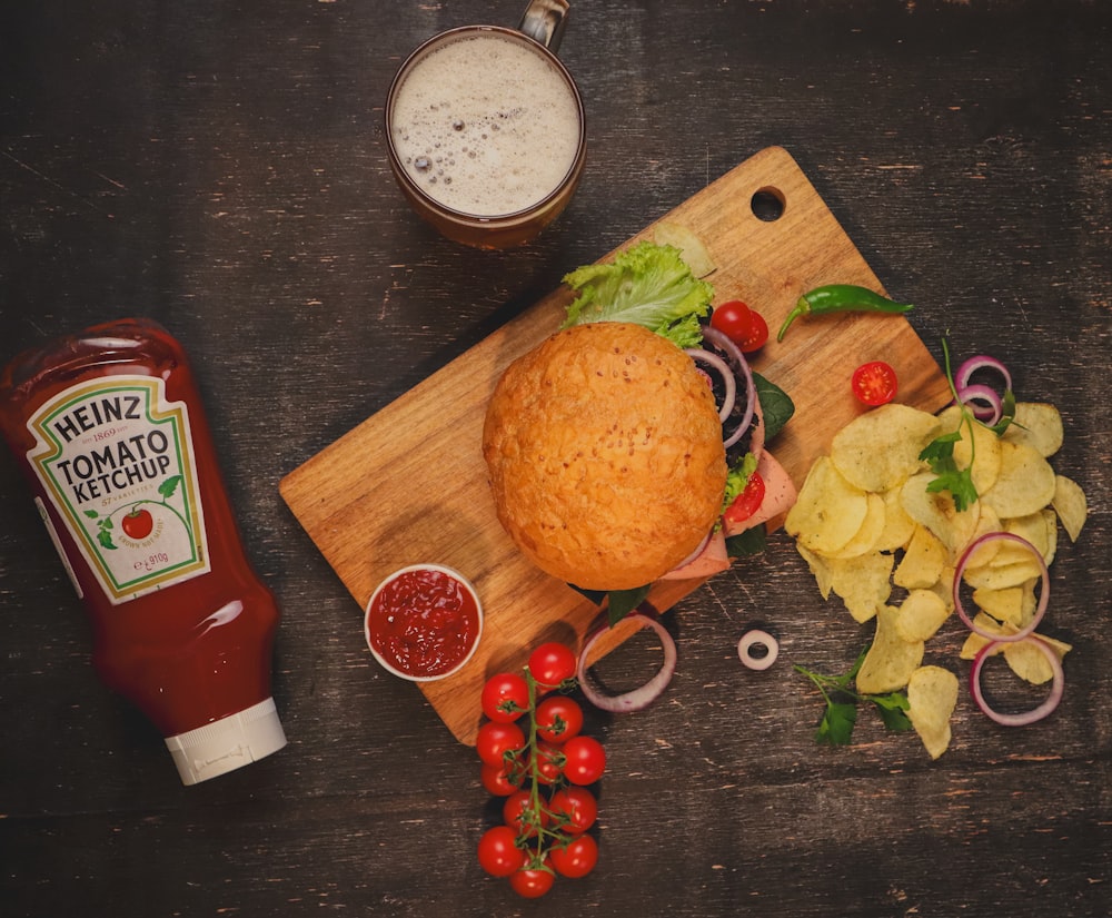 um sanduíche e batatas fritas em uma tábua de corte com ketchup