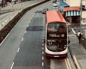a red and white double decker bus driving down a street