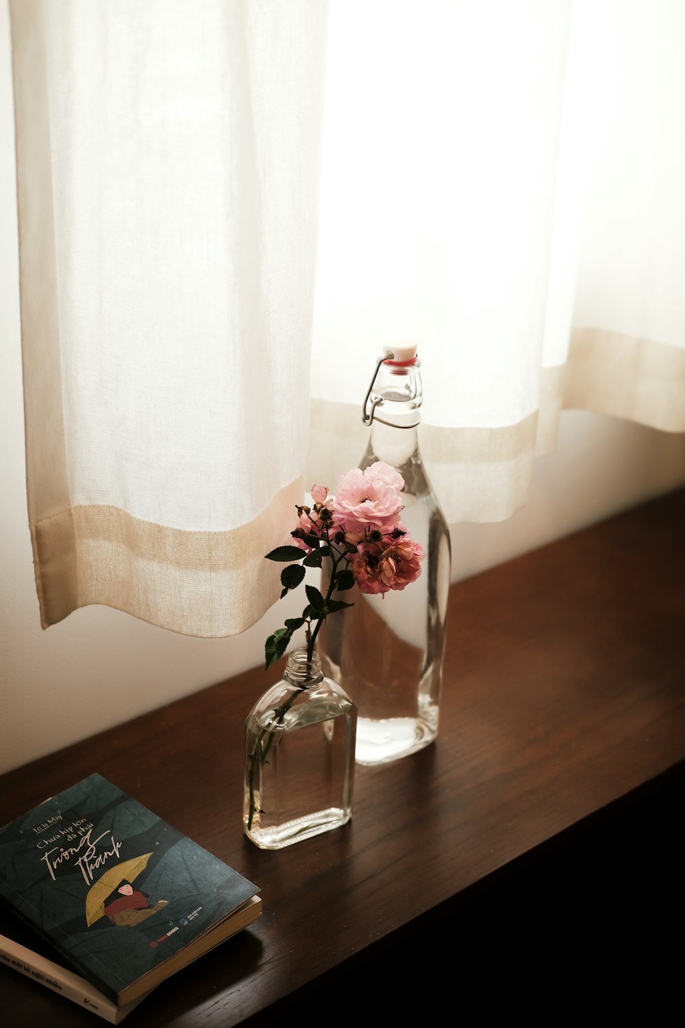 un vase avec des fleurs et un livre sur une table