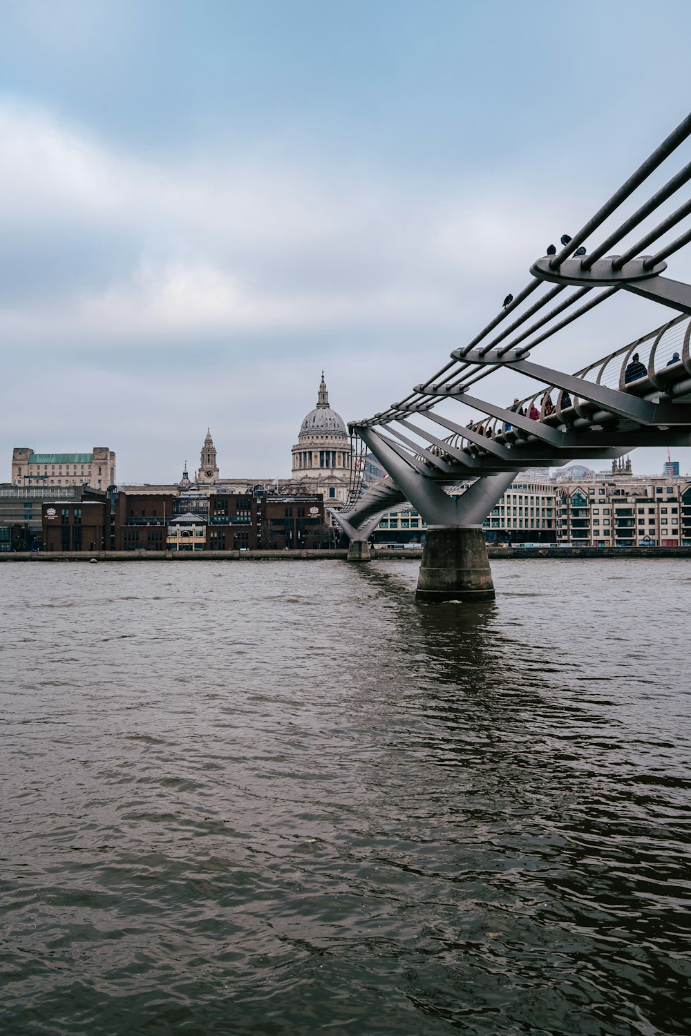 a bridge over a body of water with buildings in the background