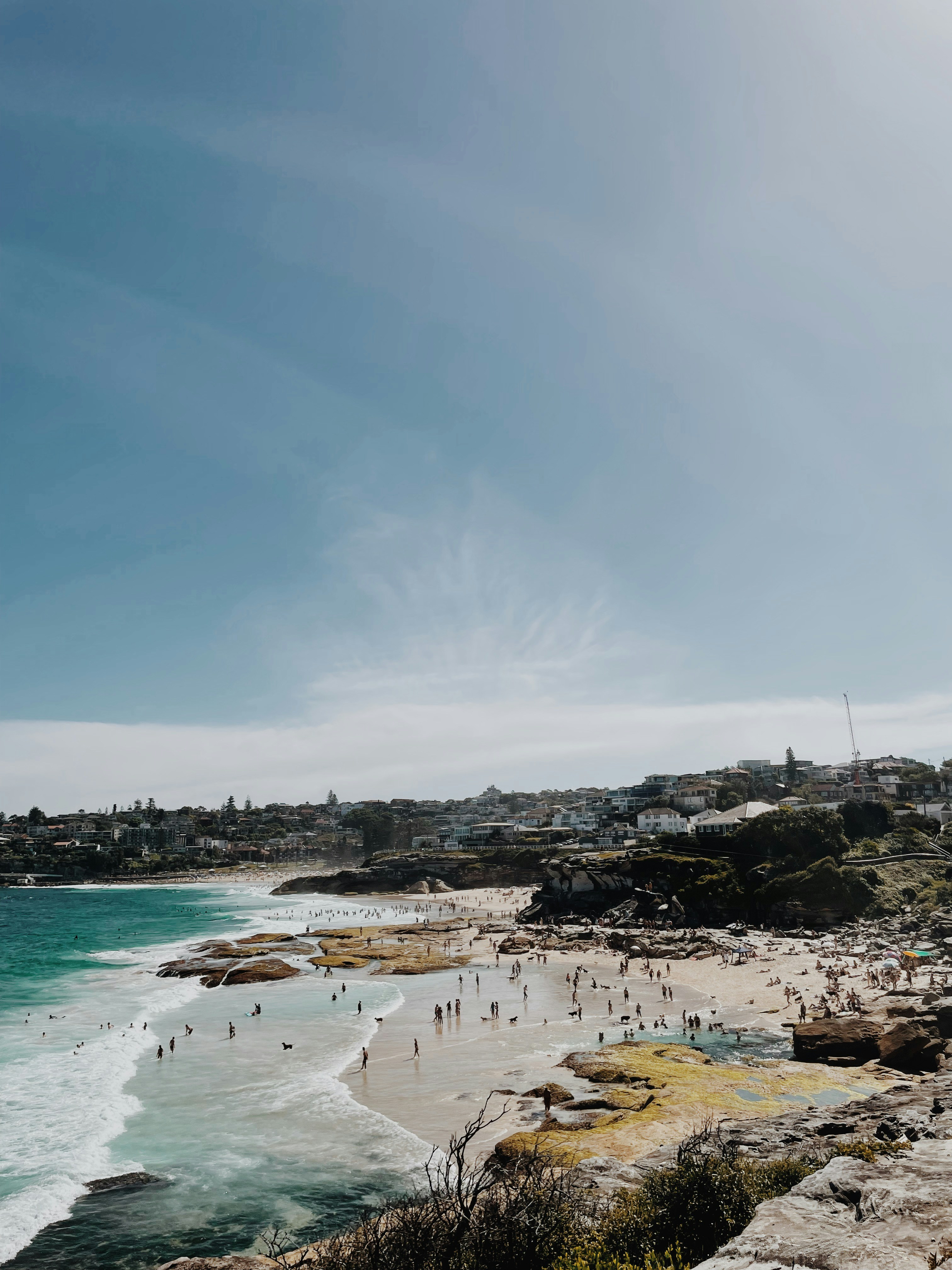 a group of people standing on top of a beach next to the ocean