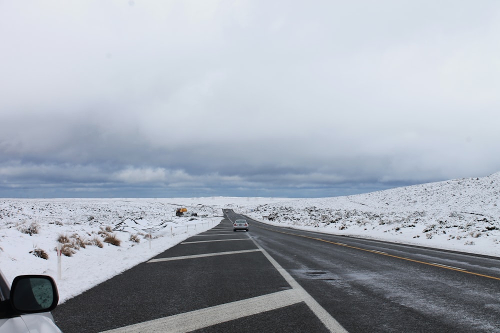 a car driving down a snow covered road