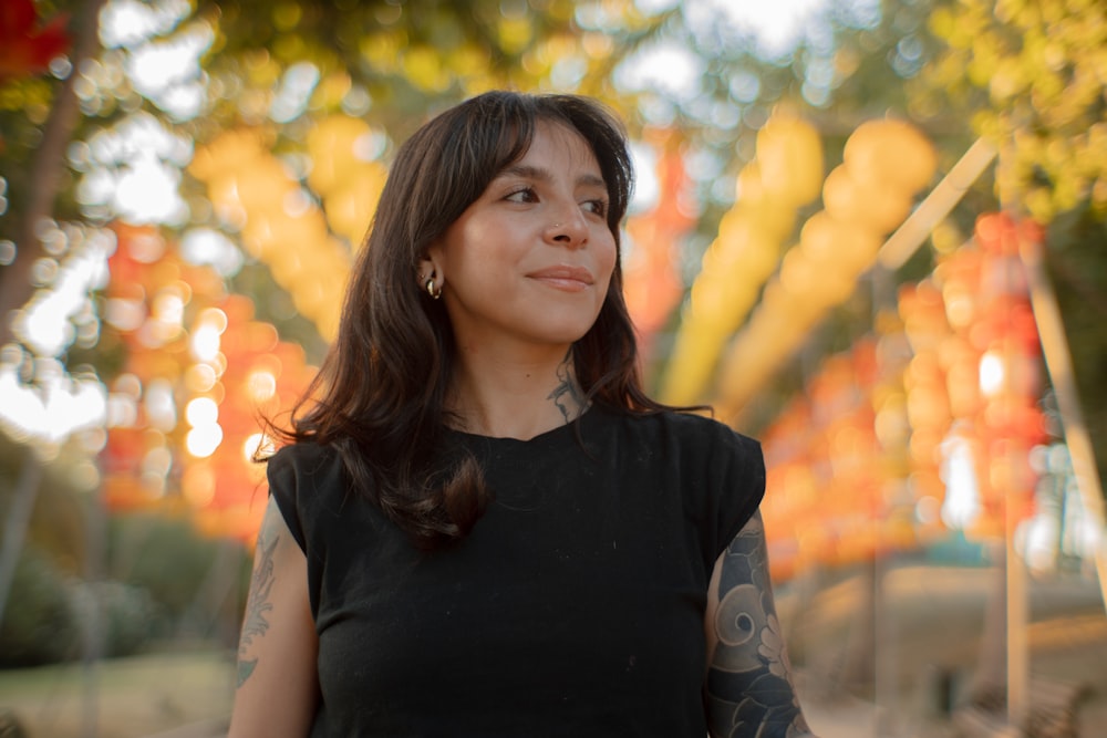 a woman in a black dress standing in a park