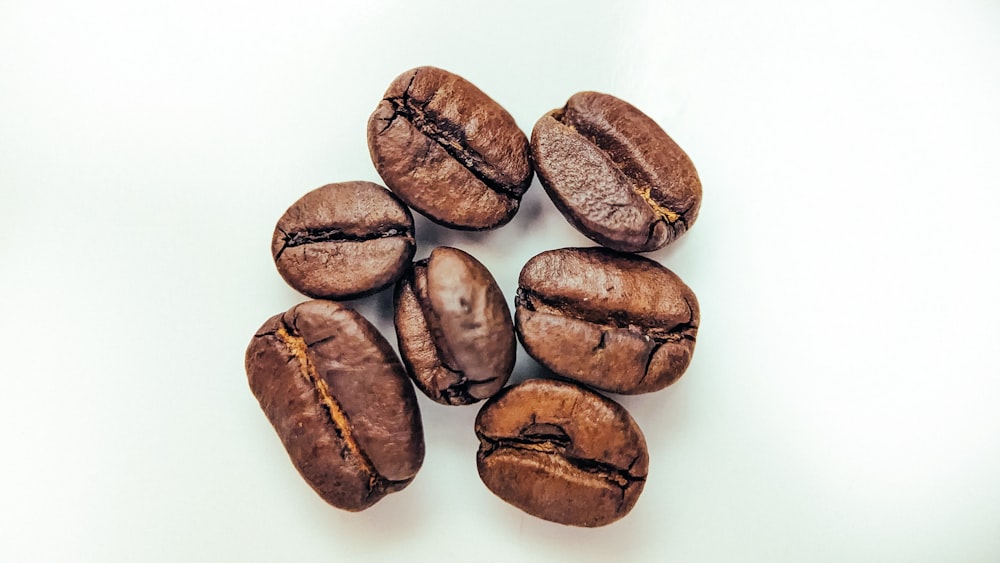 a pile of coffee beans sitting on top of a white table