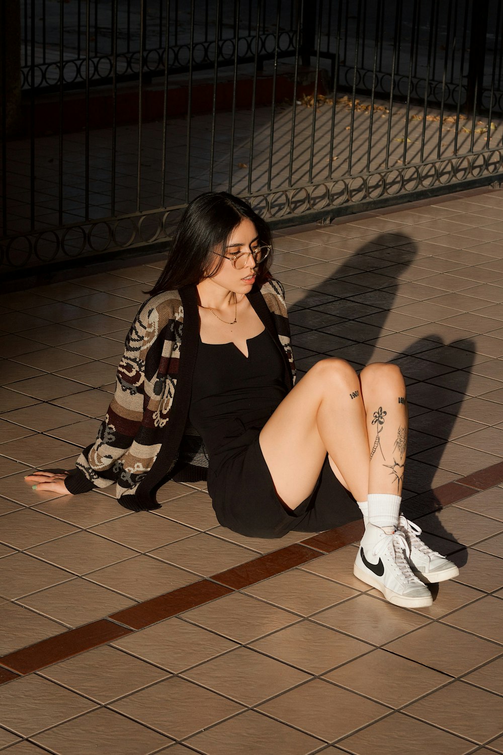 a woman sitting on the ground talking on a cell phone