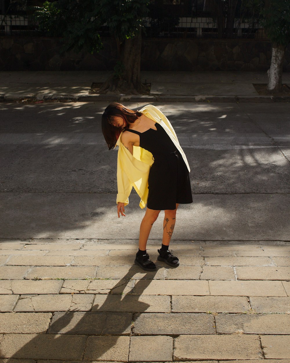 a woman in a black dress and a yellow scarf