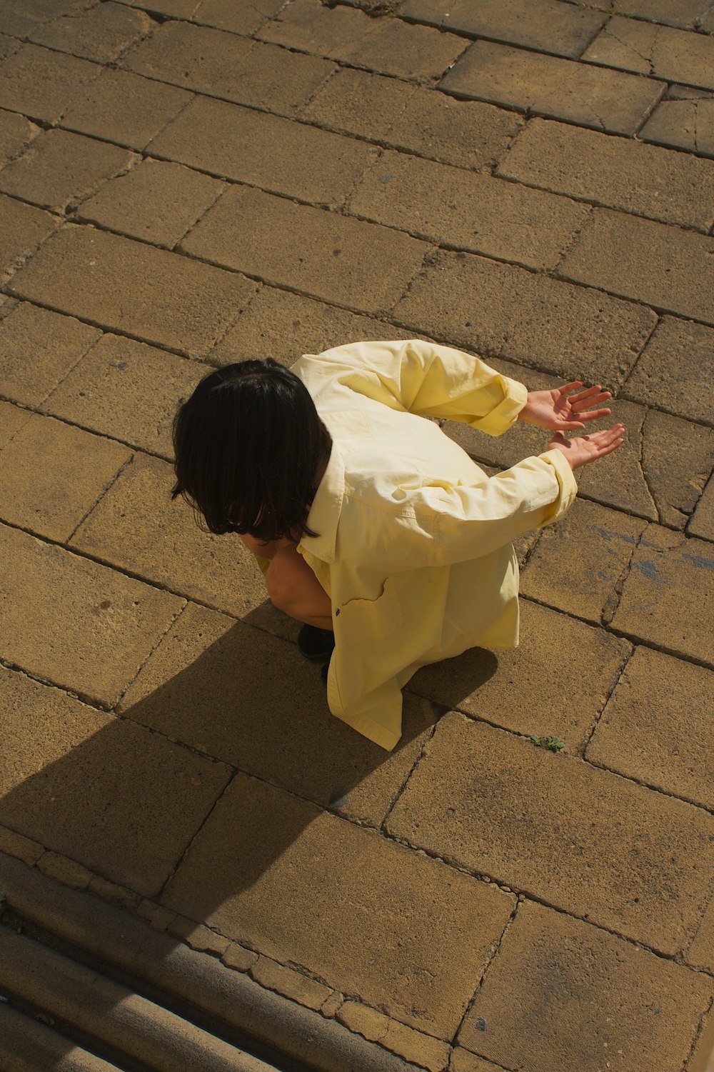 a young boy in a yellow shirt is on the ground
