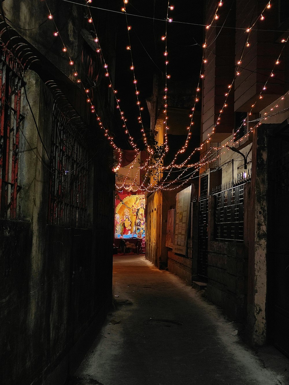 a dark alley with lights strung from the ceiling