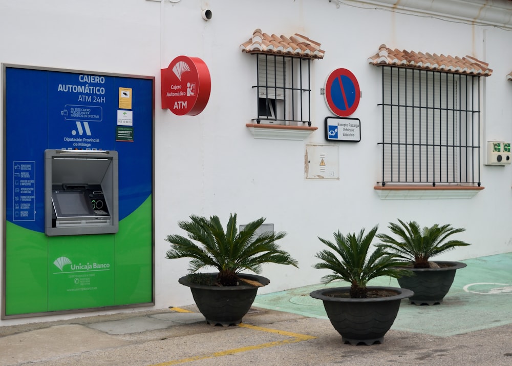 three planters with plants in front of a building