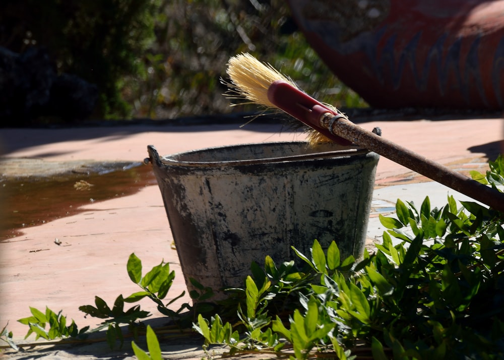 a brush sits in a bucket on the ground