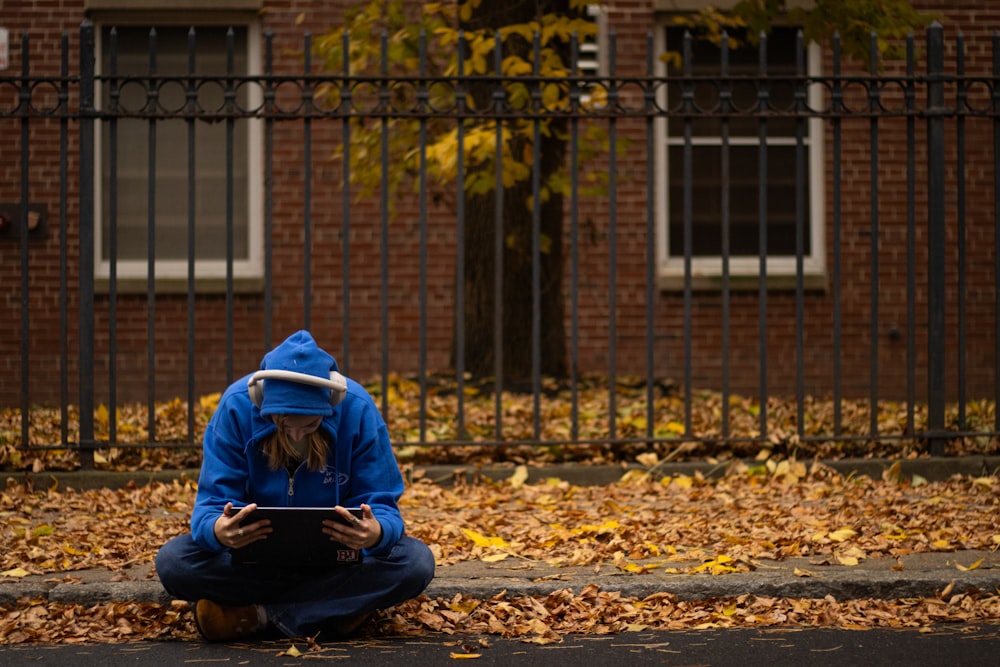 a person sitting on the ground with a tablet