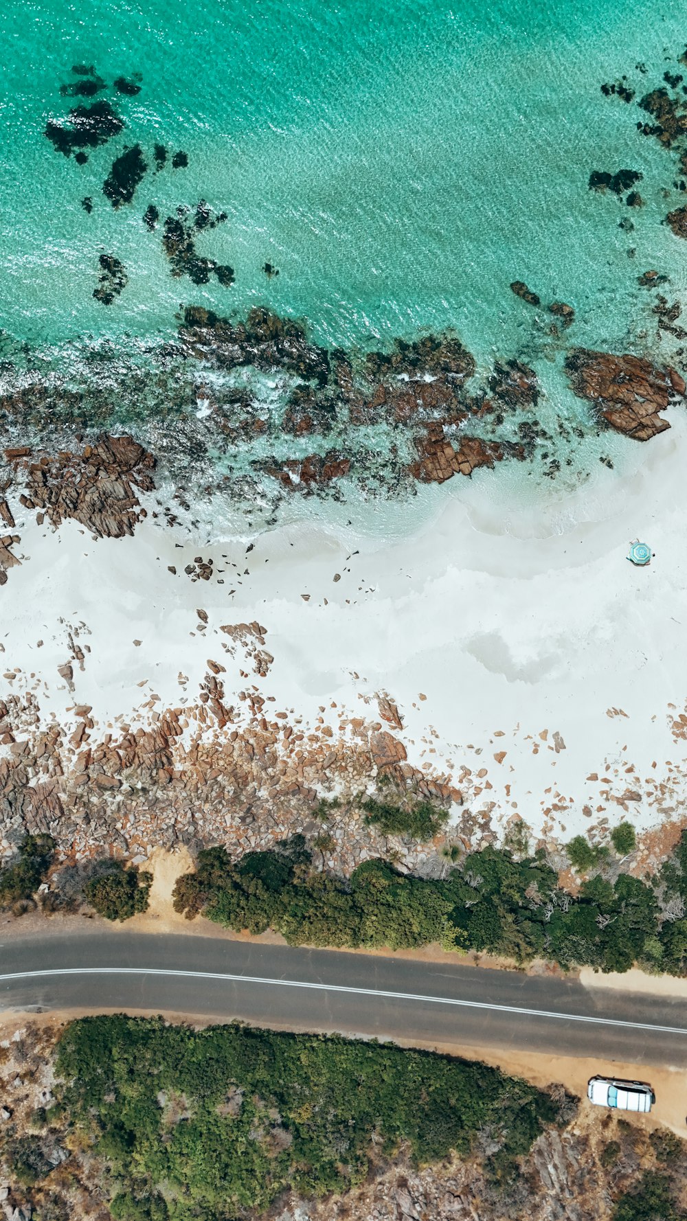 an aerial view of a road near the ocean