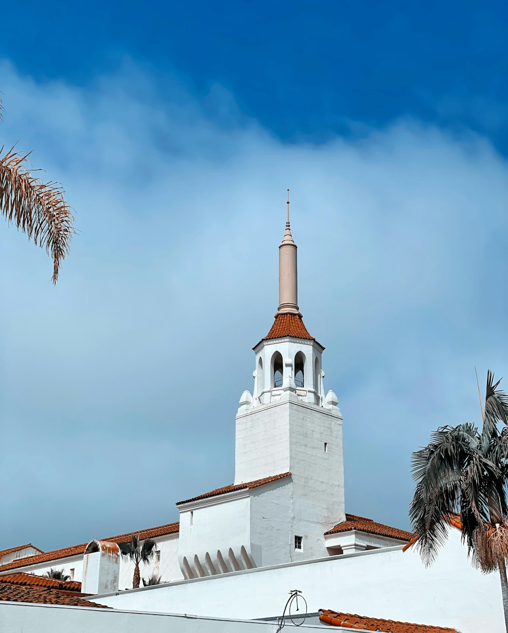 a white building with a red roof and a clock tower