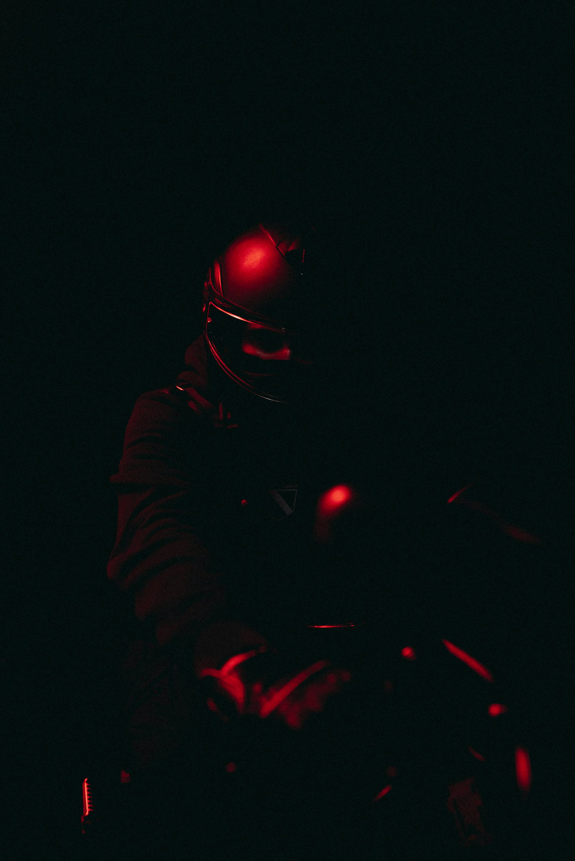a person wearing a helmet and riding a motorcycle in the dark