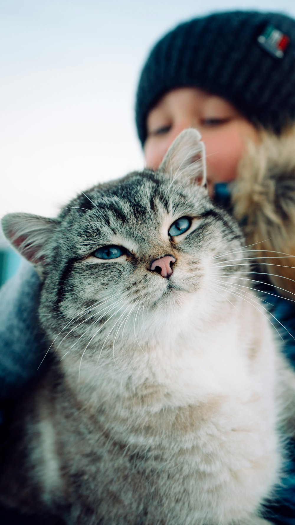 a woman is holding a cat in her arms