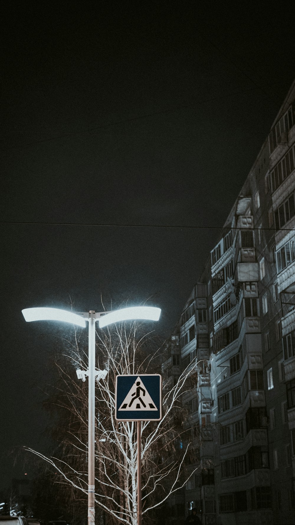 ein Straßenschild an einem Mast vor einem Gebäude