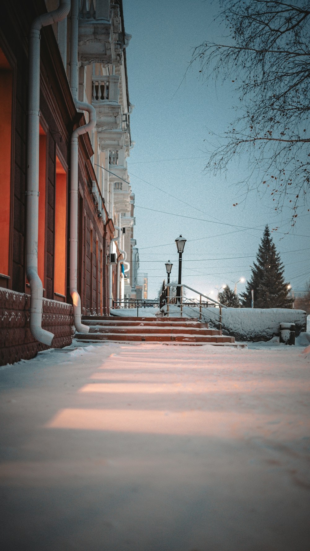 uma calçada coberta de neve ao lado de um prédio