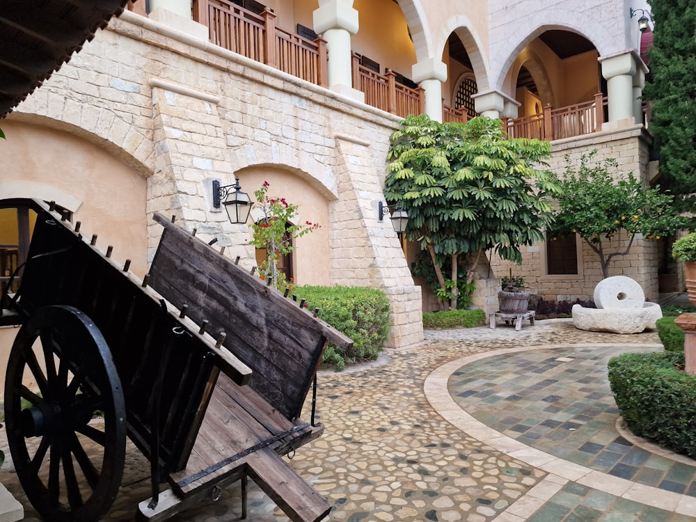 a courtyard with a wagon and a bench