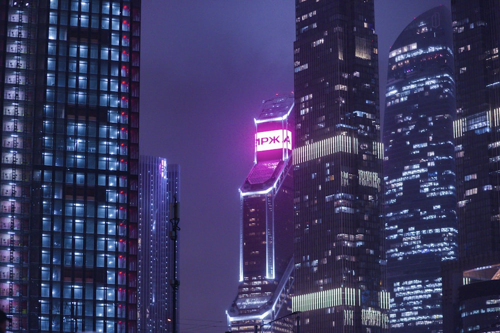 a very tall building with a neon sign on it's side