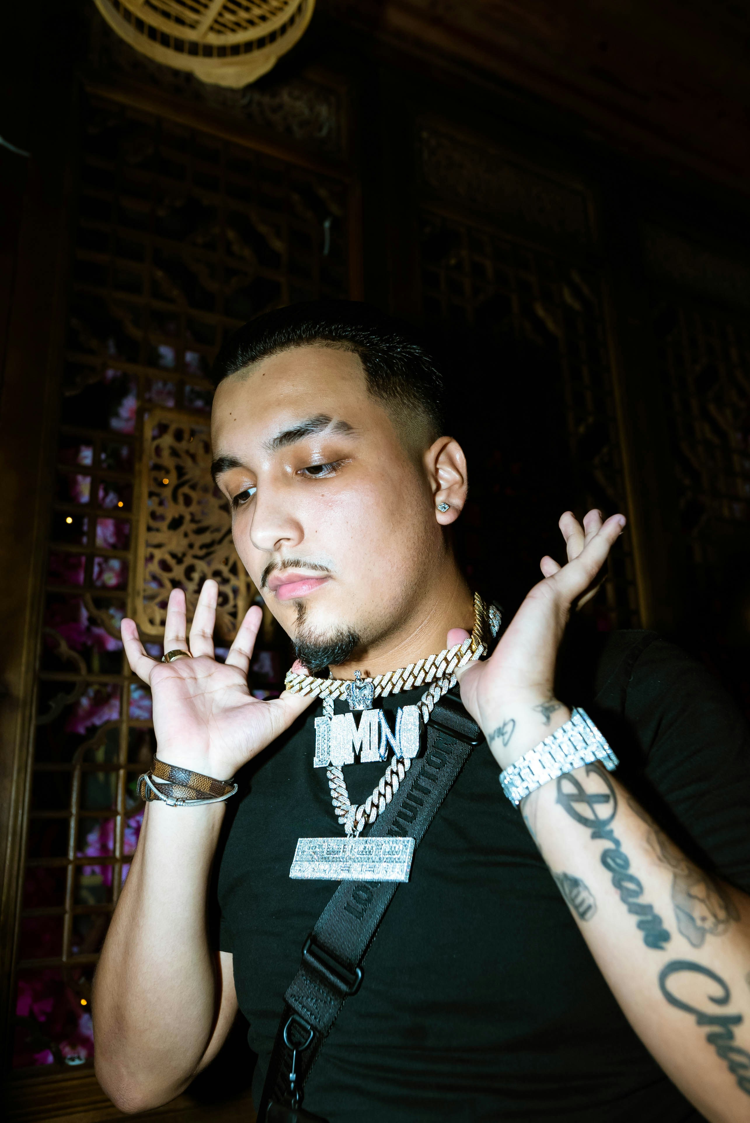 un homme vêtu d’une chemise noire levant les mains