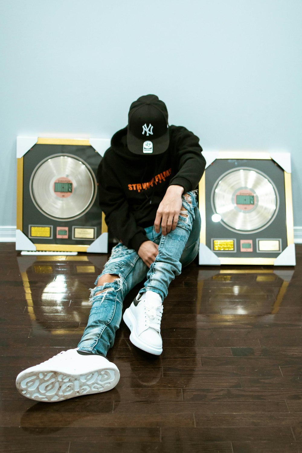 a man sitting on the floor in front of speakers