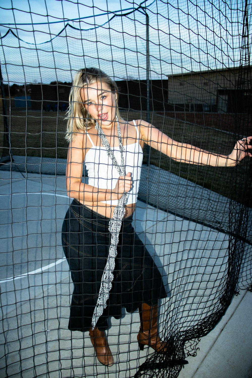 a woman standing in front of a net holding a tennis racquet