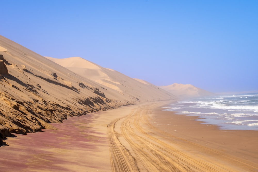 a sandy beach next to a body of water