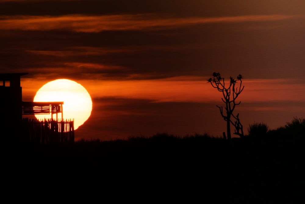 the sun is setting behind a silhouette of a building