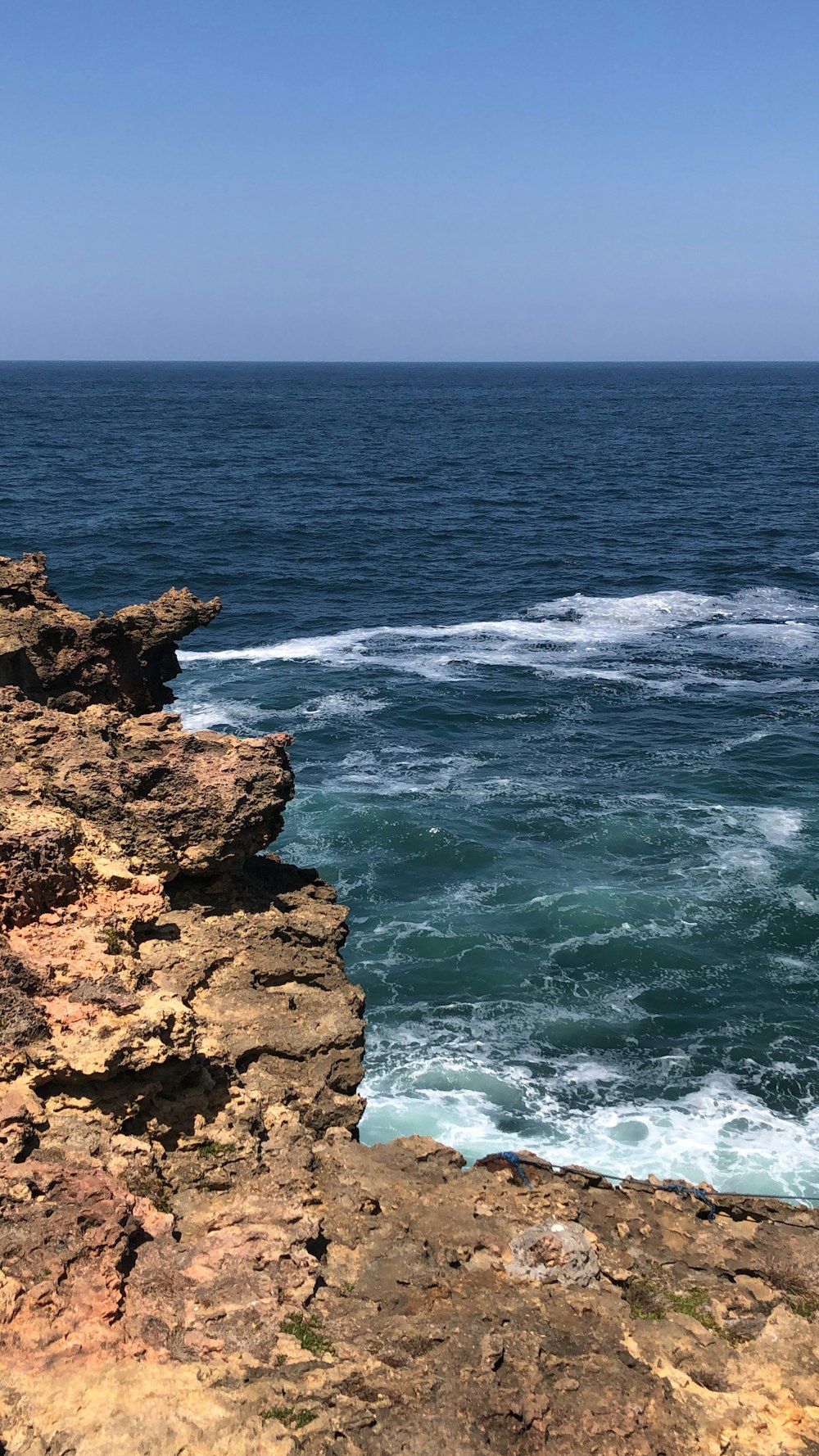 a person sitting on a cliff overlooking the ocean