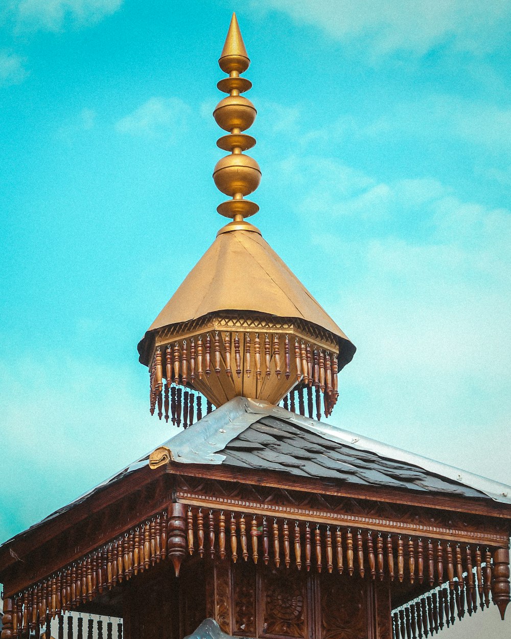 a tall wooden building with a golden roof