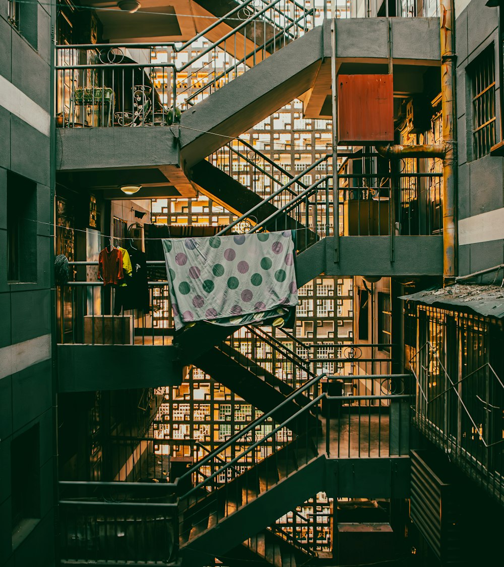 a spiral staircase in a building with a polka dot blanket hanging from it