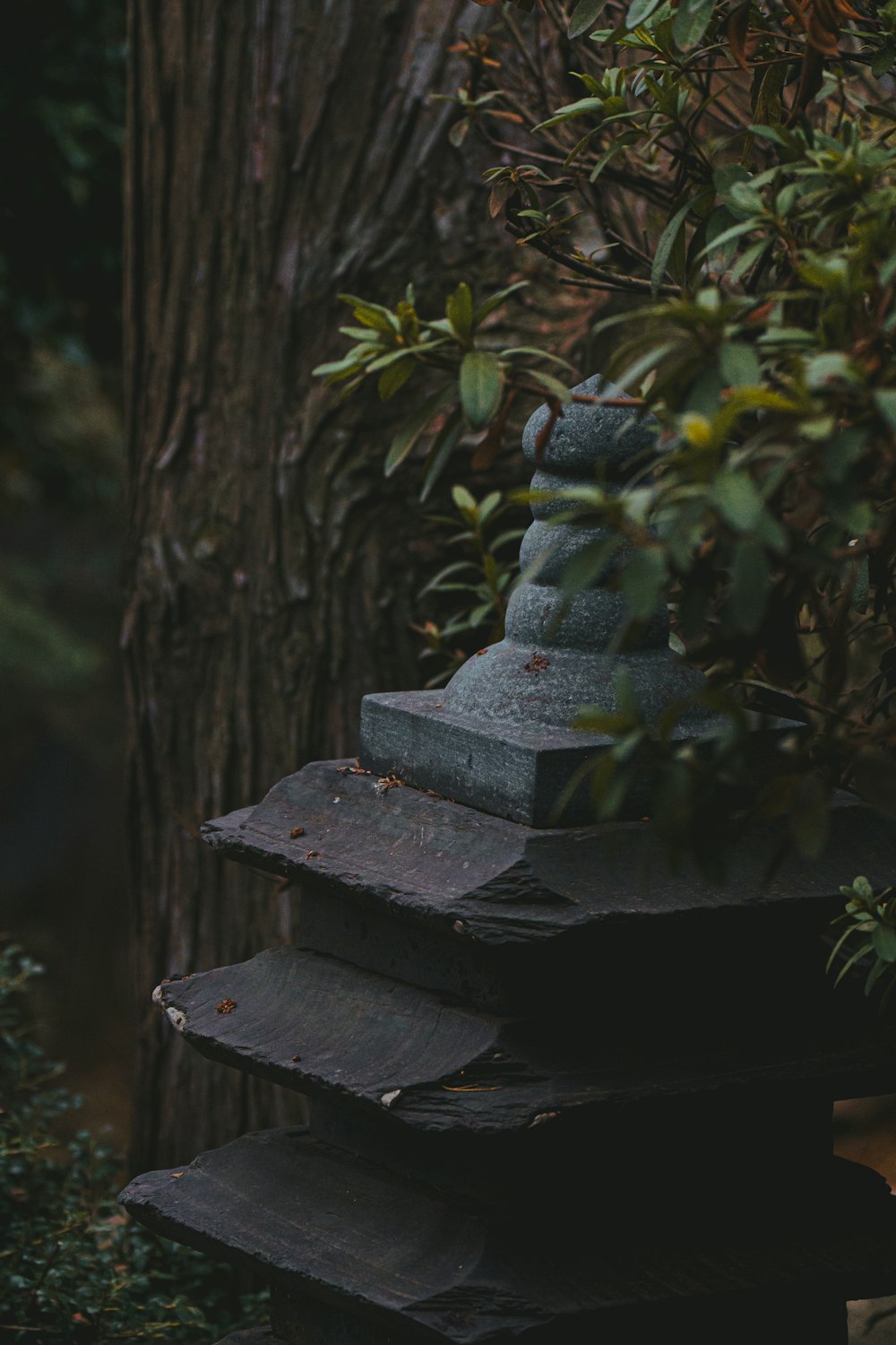 a stone statue sitting on top of a pile of wood