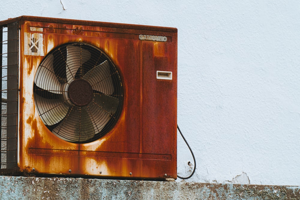 a rusty air conditioner sitting on top of a wall