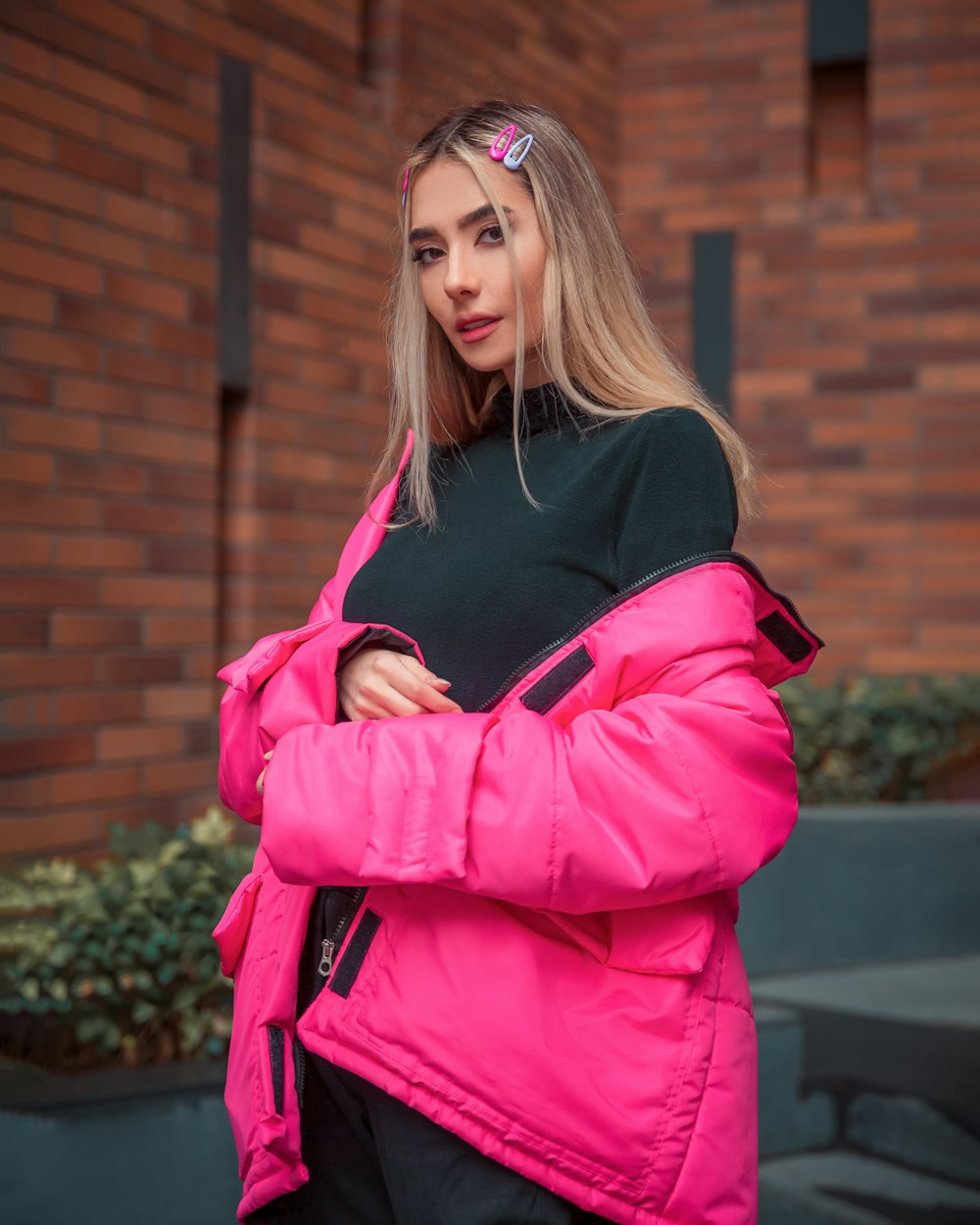 a woman in a pink jacket is standing outside