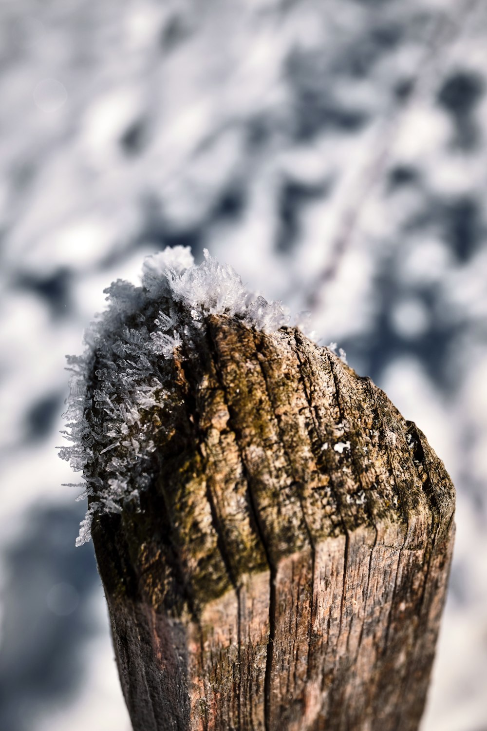 a wooden post with snow on top of it