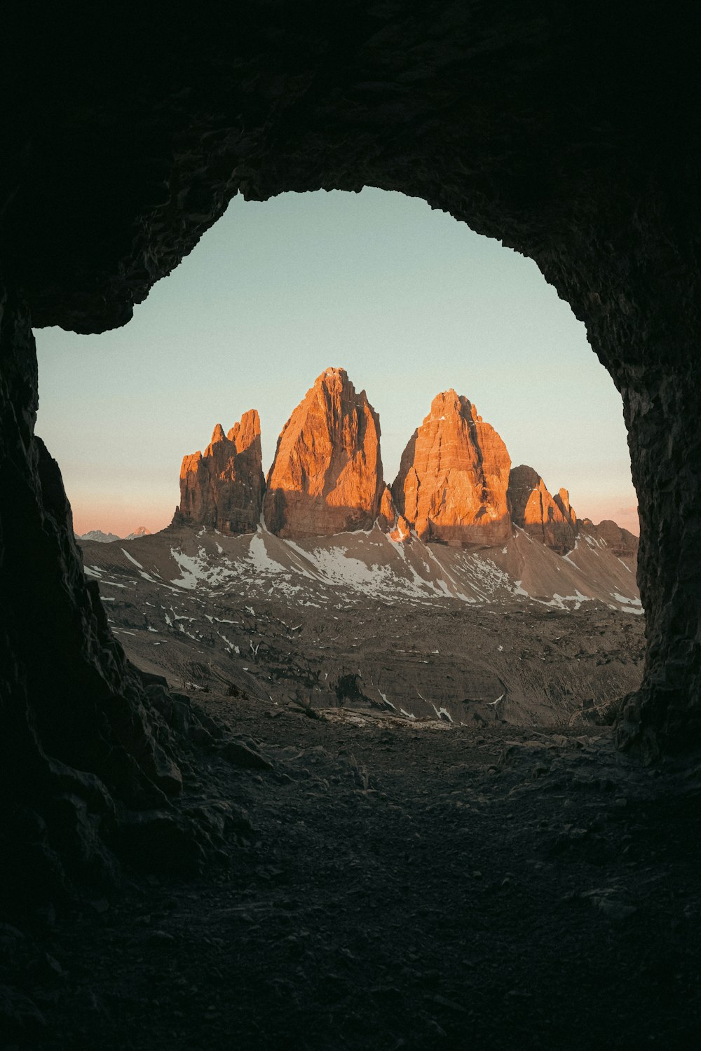 Una veduta di una catena montuosa attraverso una grotta
