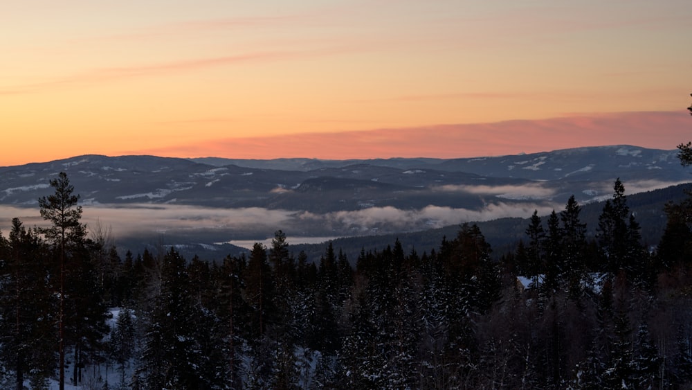 the sun is setting over a mountain range