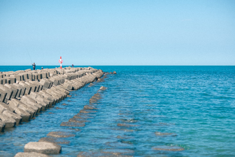 a group of people standing on the edge of a pier