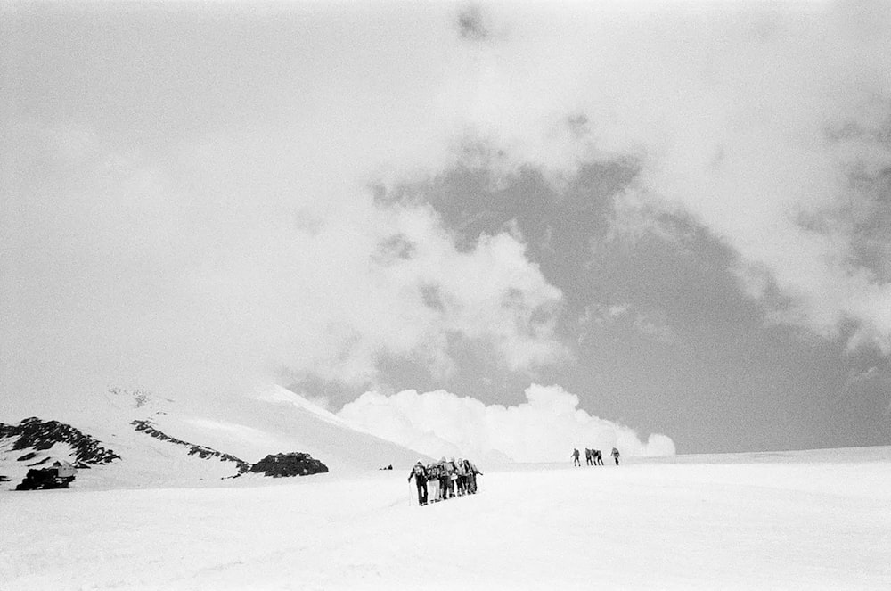 a group of people standing on top of a snow covered slope