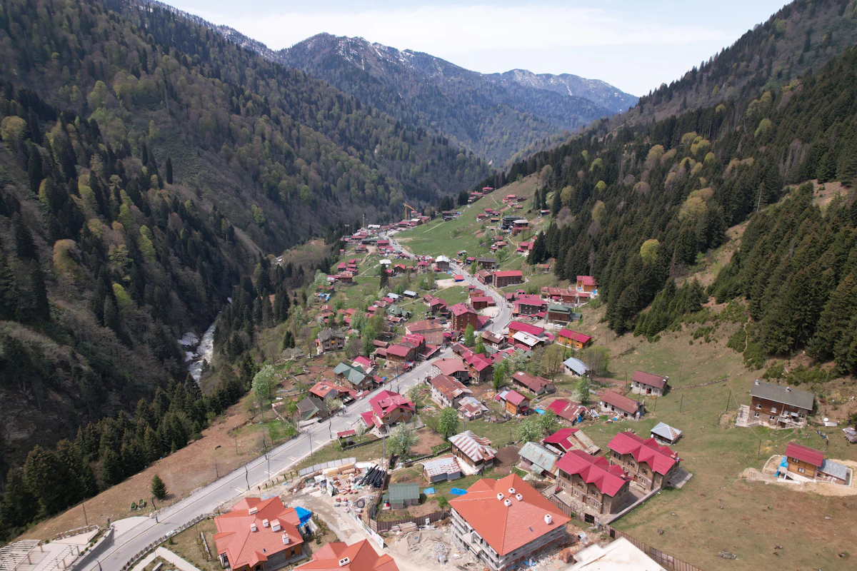 Aerial view of Ayder strung along its valley, with a road, a stream and patches of snow on the ridges at the head of the valley