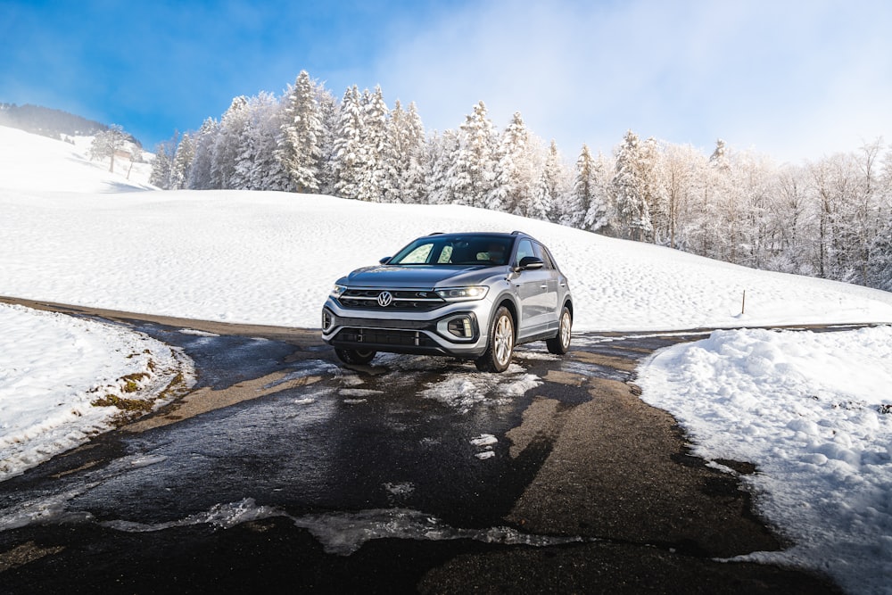 a car driving on a snowy road in the mountains