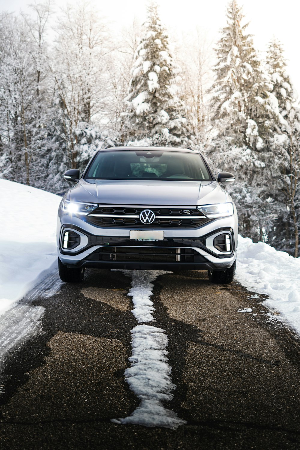 a silver volkswagen suv driving down a snowy road