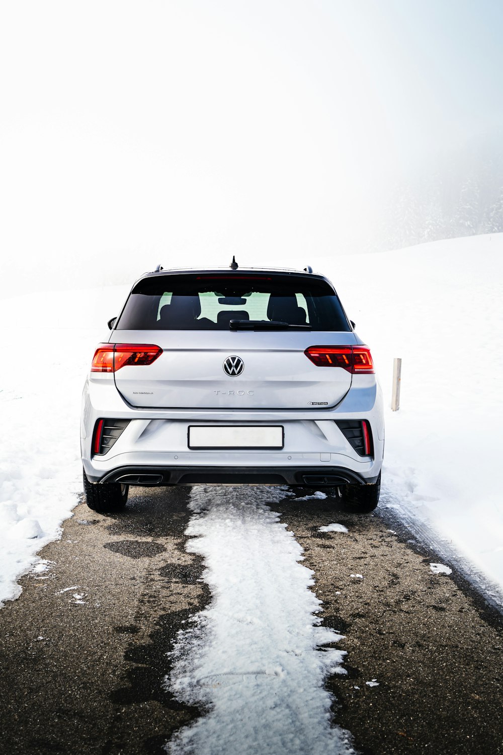 a white car parked on a snowy road