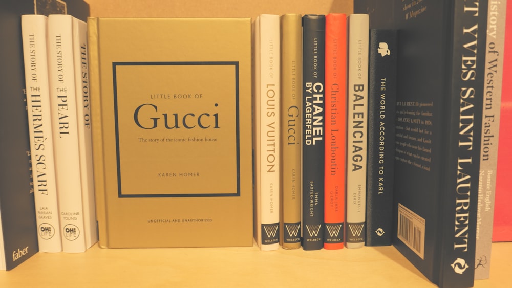 a row of books sitting on top of a wooden shelf