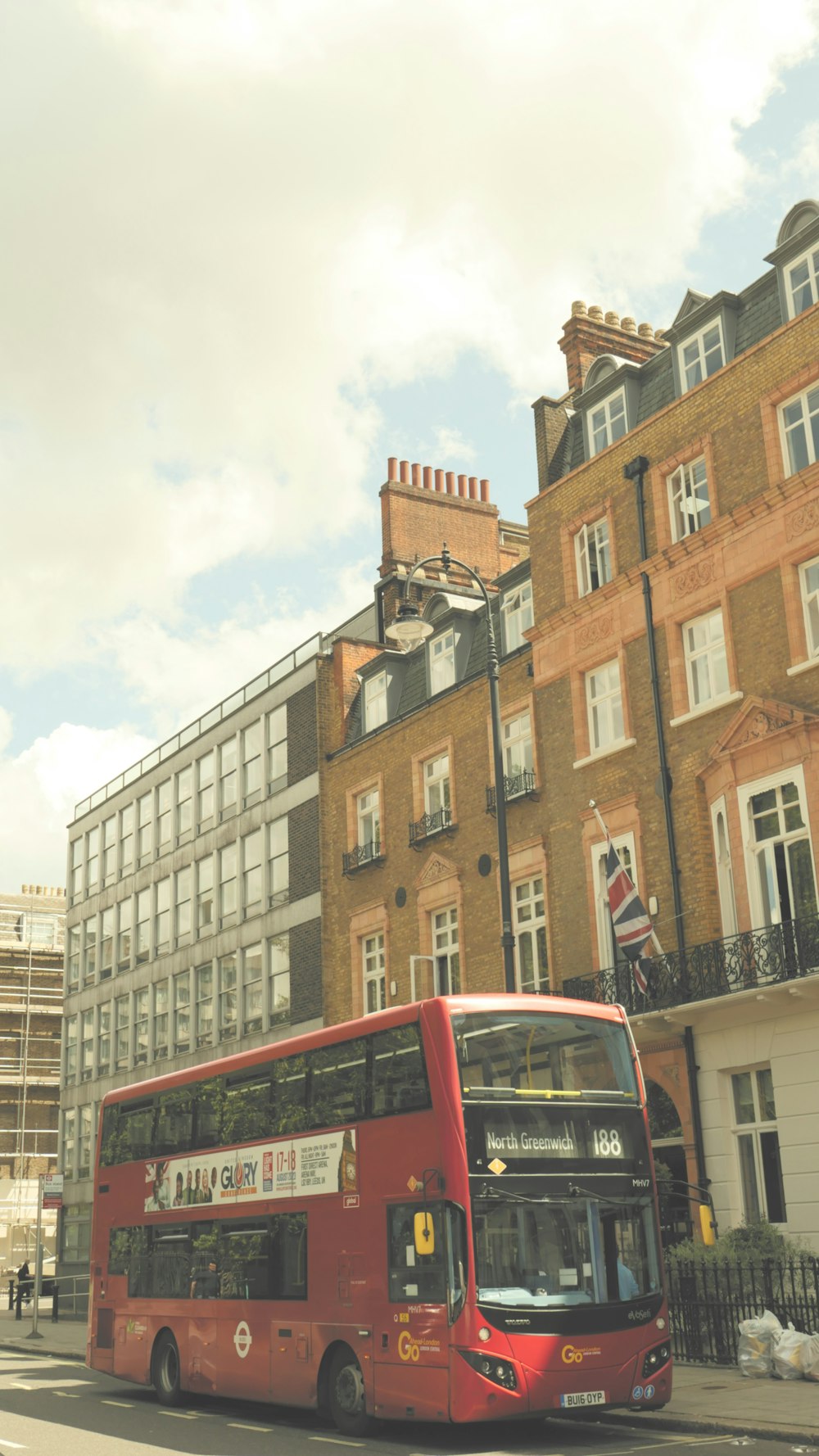 a red double decker bus driving down a street