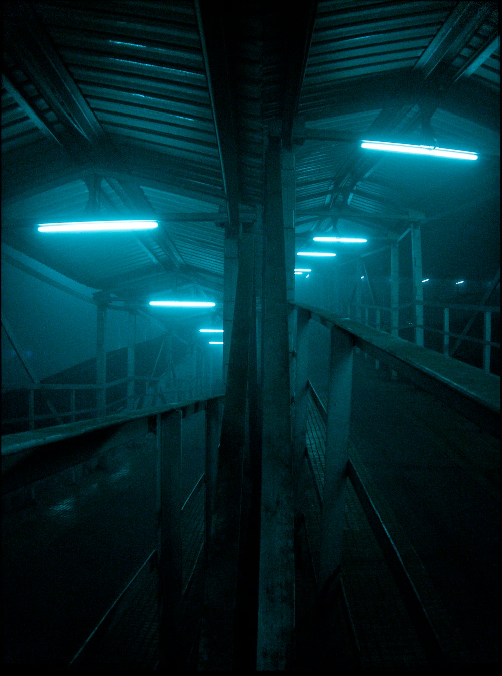 an empty parking garage with lights on the ceiling