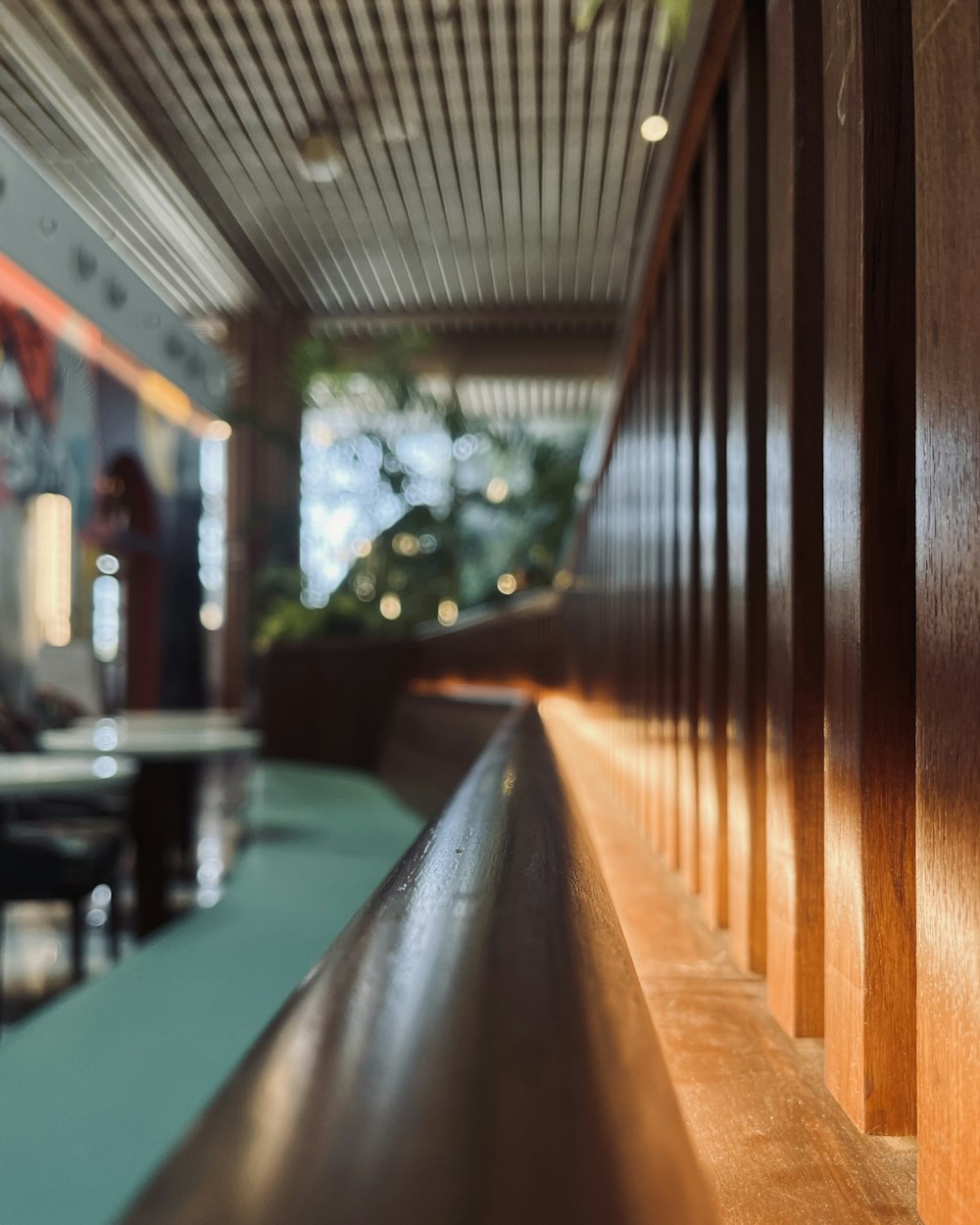 a close up of a long wooden bench near a wall