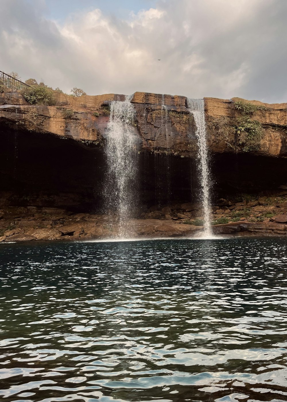 a large waterfall is coming out of the side of a cliff