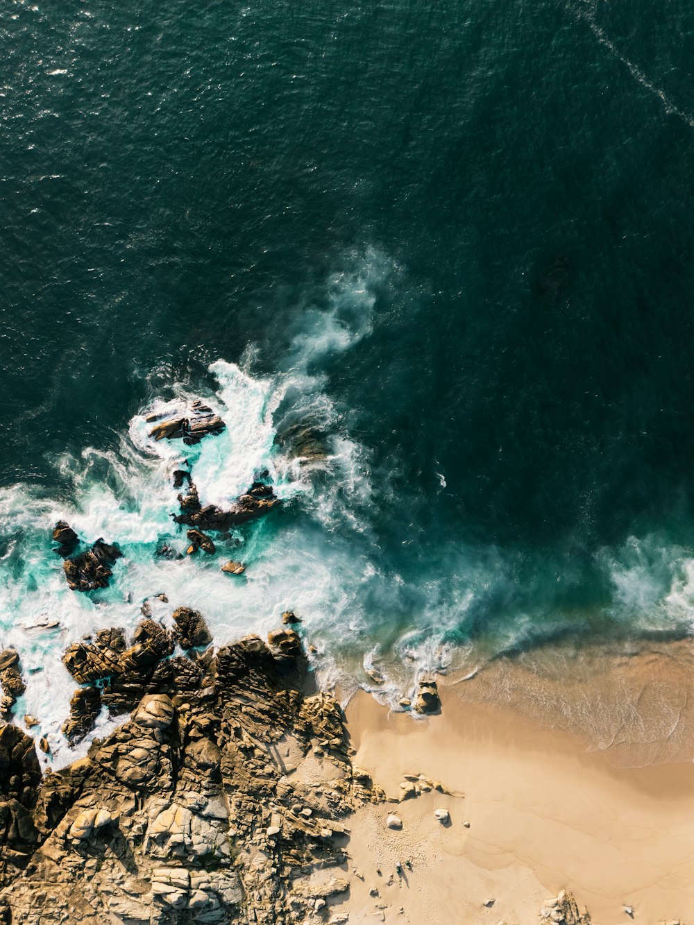 an aerial view of a rocky beach and ocean