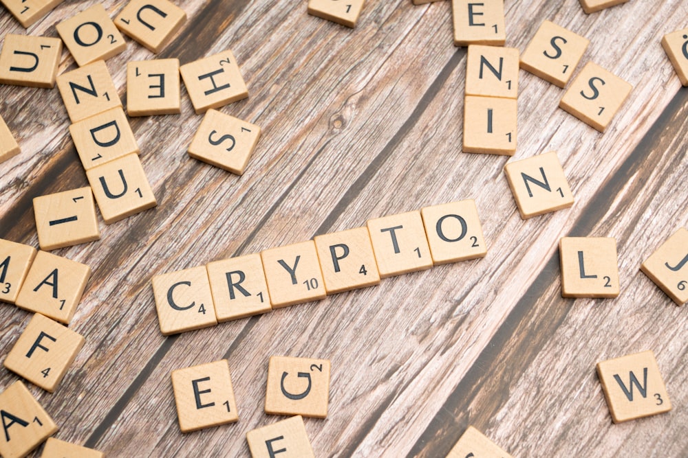 scrabble tiles spelling the word crypt on a wooden surface